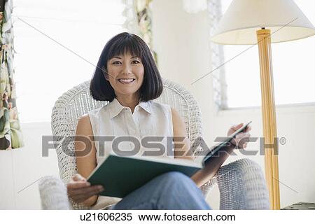 A woman sitting on chair View Large Photo Image Stock Photography - A woman sitting on chair. Fotosearch
