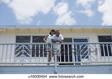 Picture - Low angle view of a couple on balcony. Fotosearch