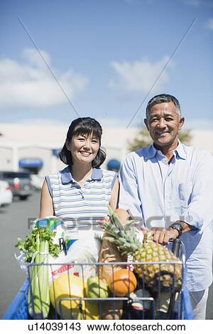 Stock Image - View of a couple with trolley. Fotosearch