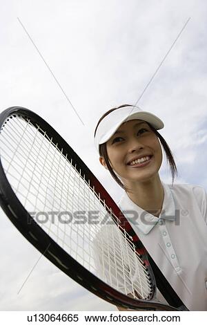 Stock Photography - A cheerful young woman holding a racquet. Fotosearch