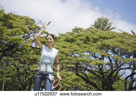 A woman holding golf club and hat View Large Photo Image Stock Photo - A woman holding golf club and hat. Fotosearch