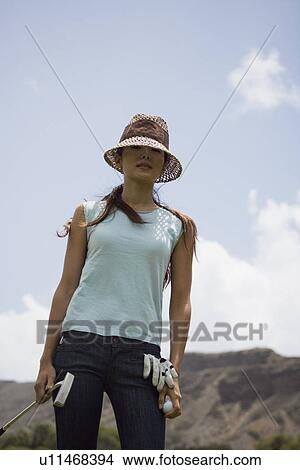 A woman holding golf club View Large Photo Image Picture - A woman holding golf club. Fotosearch