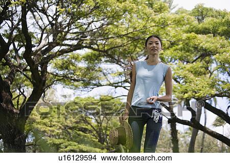 A woman standing with golf club and hat View Large Photo Image Picture - A woman standing with golf club and hat. Fotosearch