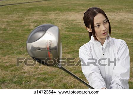 A young woman holding a golf club View Large Photo Image Picture - A young woman holding a golf club. Fotosearch