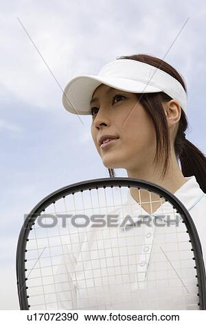 A young woman holding a racquet View Large Photo Image Stock Image - A young woman holding a racquet. Fotosearch