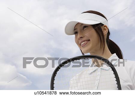A young woman holding a racquet View Large Photo Image Stock Photo - A young woman holding a racquet. Fotosearch