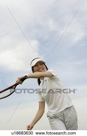 A young woman swinging a racquet View Large Photo Image Stock Image - A young woman swinging a racquet. Fotosearch