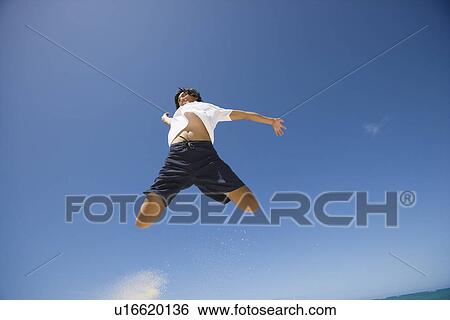 Stock Photograph - Low angle view of a young man jumping. Fotosearch