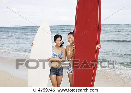 Young women standing with surfboards at beach View Large Photo Image Stock Photography - Young women standing with surfboards at beach. Fotosearch