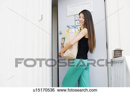 Stock Photograph - A young woman holding paper bag. Fotosearch