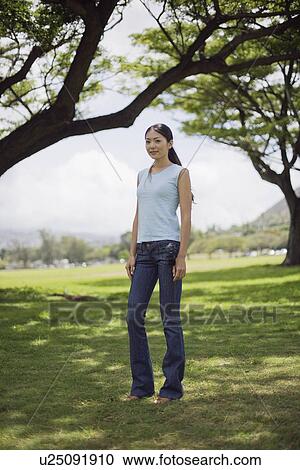 A young woman standing at park View Large Photo Image Stock Image - A young woman standing at park. Fotosearch