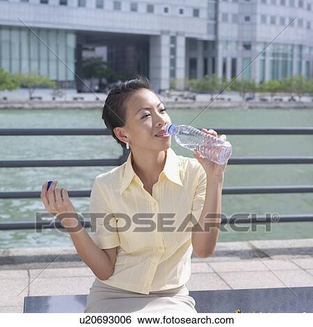 Stock Photograph - Businesswoman drinking water from a bottle. Fotosearch