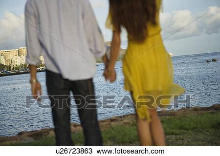 Midsection of a couple holding hands View Large Photo Image Stock Image - Midsection of a couple holding hands. Fotosearch