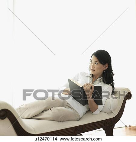 Picture - Young woman holding a book in her hand. Fotosearch