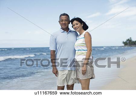 A couple smiling at beach View Large Photo Image Stock Photo - A couple smiling at beach. Fotosearch