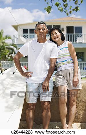 A couple standing near surfboard View Large Photo Image Stock Photo - A couple standing near surfboard. Fotosearch