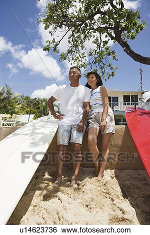 A couple standing near surfboards View Large Photo Image Stock Photograph - A couple standing near surfboards. Fotosearch