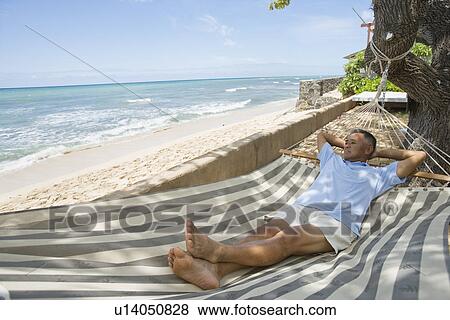 Mature man lying on hammock View Large Photo Image Stock Photo - Mature man lying on hammock. Fotosearch