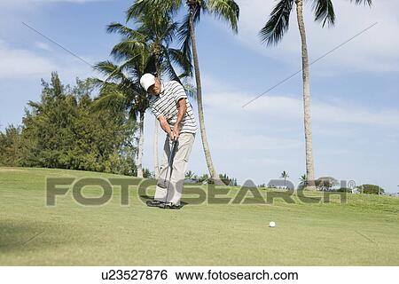 Stock Photograph - Mature man playing golf. Fotosearch