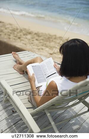 Stock Photo - Rear view of a woman reading book. Fotosearch