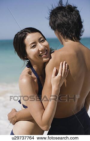 A young couple embracing at beach View Large Photo Image Picture - A young couple embracing at beach. Fotosearch