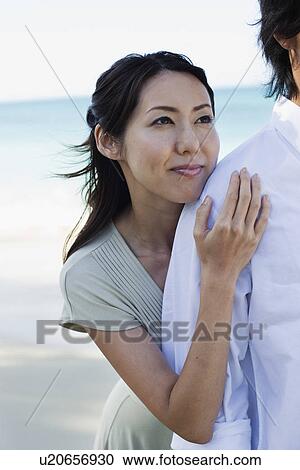 Stock Image - A young couple standing at beach. Fotosearch