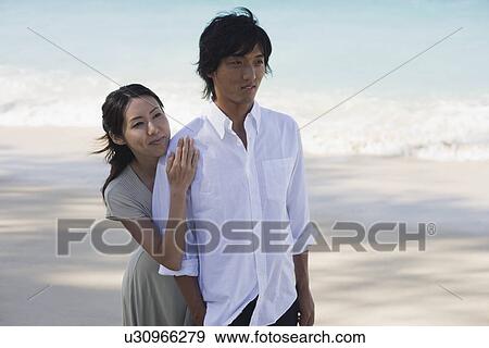 A young couple standing at beach View Large Photo Image Stock Photo - A young couple standing at beach. Fotosearch