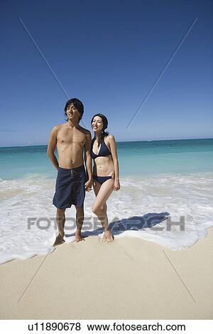 A young couple standing on beach View Large Photo Image Stock Photo - A young couple standing on beach. Fotosearch