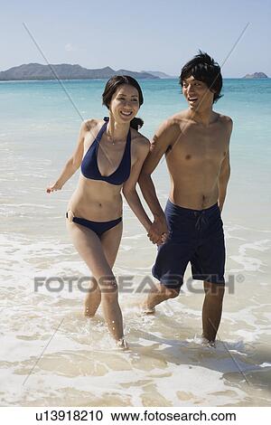 A young couple walking in sea View Large Photo Image Stock Image - A young couple walking in sea. Fotosearch