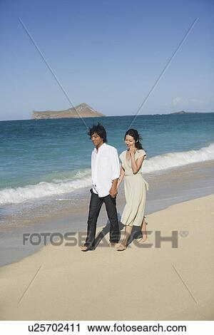 A young couple walking on beach View Large Photo Image Stock Image - A young couple walking on beach. Fotosearch