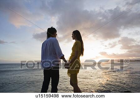 Profile of a young couple standing at beach View Large Photo Image Stock Photo - Profile of a young couple standing at beach. Fotosearch