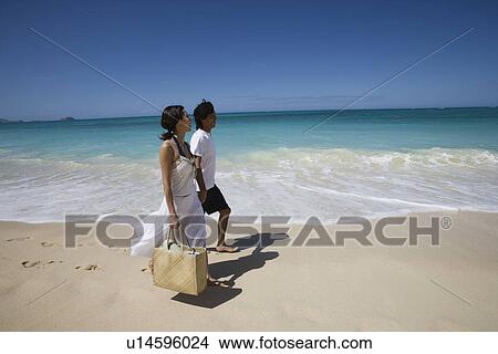 Picture - Profile of a young couple walking on beach. Fotosearch