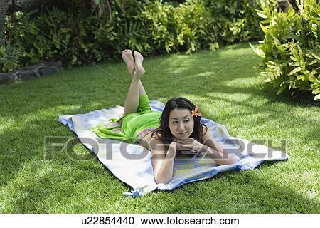A smiling young woman relaxing in garden View Large Photo Image Stock Image - A smiling young woman relaxing in garden. Fotosearch