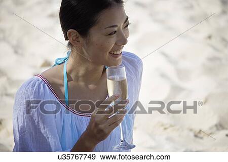 A young woman holding wineglass, looking away View Large Photo Image Stock Photo - A young woman holding wineglass, looking away. Fotosearch