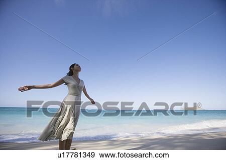 A young woman standing on beach View Large Photo Image Stock Photo - A young woman standing on beach. Fotosearch