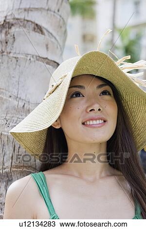 Stock Image - Close-up of a young woman smiling looking upwards. Fotosearch