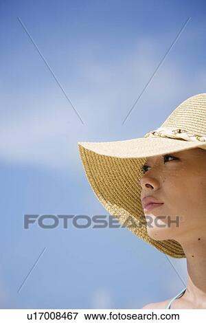 Close-up of a young woman wearing hat View Large Photo Image Stock Photo - Close-up of a young woman wearing hat. Fotosearch