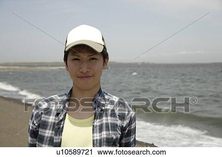 Portrait of a young man smiling on beach View Large Photo Image Stock Image - Portrait of a young man smiling on beach. Fotosearch