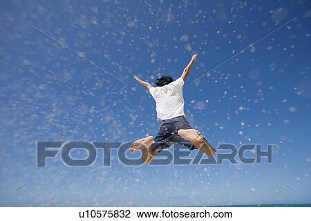 Rear view of a man jumping View Large Photo Image Stock Image - Rear view of a man jumping. Fotosearch