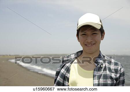 Portrait of a young man smiling on beach View Large Photo Image Stock Photo - Portrait of a young man smiling on beach. Fotosearch
