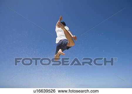 Rear view of a man jumping View Large Photo Image Stock Photograph - Rear view of a man jumping. Fotosearch