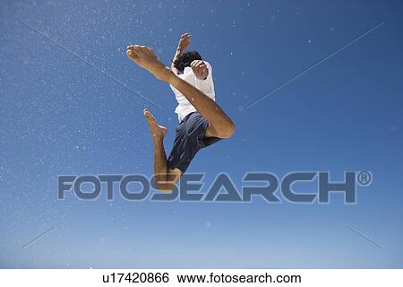 Rear view of a man jumping View Large Photo Image Stock Photograph - Rear view of a man jumping. Fotosearch