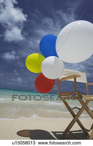 View of air balloons on wooden chair at beach View Large Photo Image Stock Image - View of air balloons on wooden chair at beach. Fotosearch
