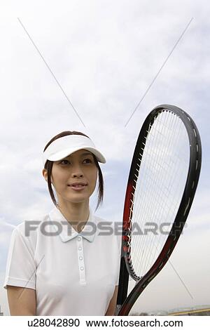 A young woman holding a racquet View Large Photo Image Stock Image - A young woman holding a racquet. Fotosearch