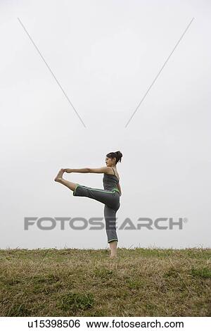 Stock Photograph - Side view of a young woman exercising outdoors. Fotosearch