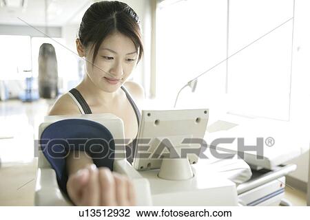 A young woman checks her pulse rate and blood pressure on the digital indicator View Large Photo Image Stock Image - A young woman checks her pulse rate and blood pressure on the digital indicator. Fotosearch