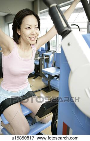 A young woman exercising her thighs and shoulders on the latest equipment in the gym View Large Photo Image Stock Photo - A young woman exercising her thighs and shoulders on the latest equipment in the gym. Fotosearch