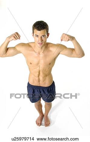Portrait of a young man flexing his muscles and standing on a weighing scale View Large Photo Image Picture - Portrait of a young man flexing his muscles and standing on a weighing scale. Fotosearch