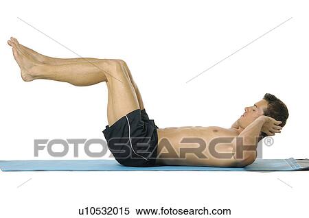 Stock Photography - Side profile of a young man doing sit-ups. Fotosearch