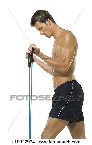 Side profile of a young man exercising with a resistance band View Large Photo Image Picture - Side profile of a young man exercising with a resistance band. Fotosearch